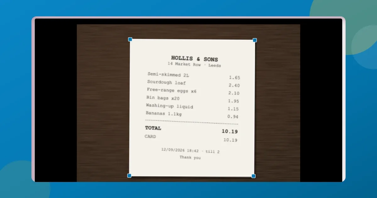 ToolsTray's document scanner in Crop mode: a till receipt photographed on a wooden desk, with the four corner handles sitting on the paper's edges.