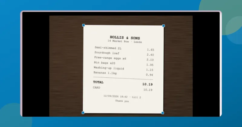 ToolsTray's document scanner in Crop mode: a till receipt photographed on a wooden desk, with the four corner handles sitting on the paper's edges.
